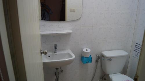 a bathroom with a sink and a toilet and a mirror at Kata Apartment in Kata Beach