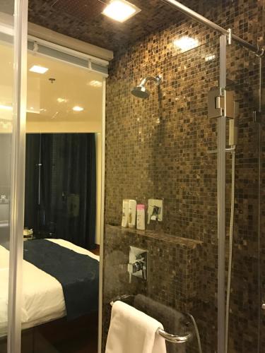 a bathroom with a shower and a bed in a room at The palm wongamat pattaya in North Pattaya