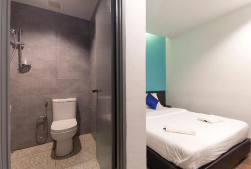 a small bathroom with a toilet and a shower at Clover Hotel Ipoh in Ipoh