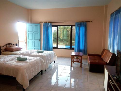 een slaapkamer met een bed, een bank en een raam bij Peace Pool Resort in Khun Han