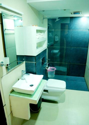 a bathroom with a toilet and a sink and a shower at Hotel Horizon International in Guruvāyūr