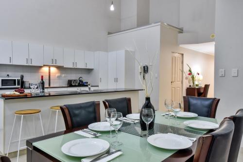 a dining room with a table and chairs and a kitchen at Argus Apartments Darwin in Darwin