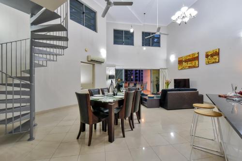 a dining room and living room with a table and chairs at Argus Apartments Darwin in Darwin