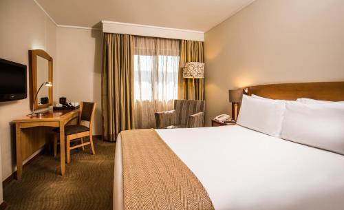 a hotel room with a bed and a desk at Garden Court Eastgate in Johannesburg
