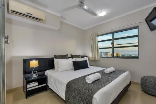 a bedroom with a large bed and a window at Argus Apartments Darwin in Darwin