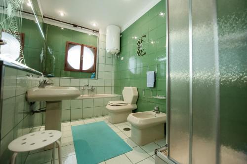 a green bathroom with a toilet and a sink at Casa vacanze Maria in Agropoli