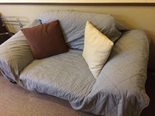 a couch with three pillows on top of it at Shikino Yado Subaru in Chino