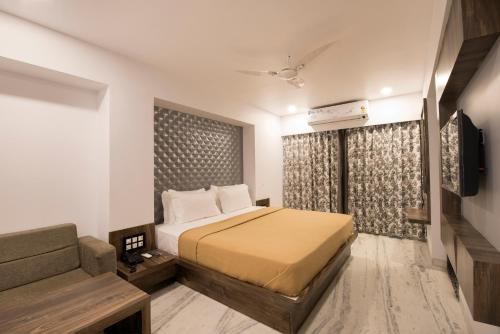 a hotel room with a bed and a couch at Hotel Sanmukh By Adamo in Nāthdwāra