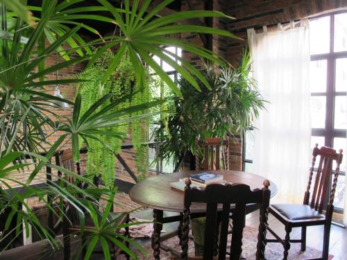 uma mesa e cadeiras numa sala com plantas em J No.14 em Bangkok