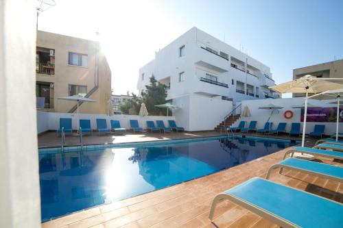 a swimming pool with blue chairs and a building at Flora Maria Hotel in Ayia Napa