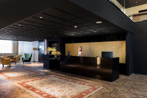 a woman is standing in the lobby of a building at Leonardo Boutique Jerusalem in Jerusalem