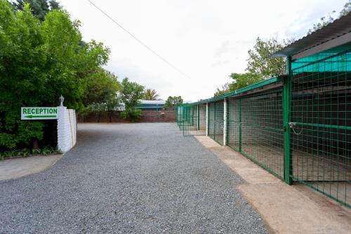 a fence next to a building with a gate at Colesview Guest House in Colesberg