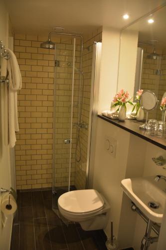 a bathroom with a toilet and a sink and a shower at Hotel Gilleleje Strand in Gilleleje
