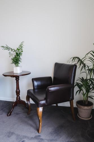 a black leather chair and a table with two plants at Hotel Gilleleje Strand in Gilleleje