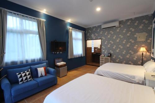 a hotel room with a bed and a couch at Jing Lai Hui Lan Homestay in Ruisui
