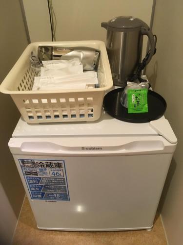 - une cafetière installée au-dessus d'un lave-linge dans l'établissement Hotel Asahi Grandeur Fuchu, à Fuchu