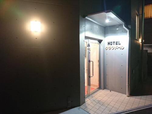 a hallway of a building with a light on the wall at Hotel Asahi Grandeur Fuchu in Fuchu