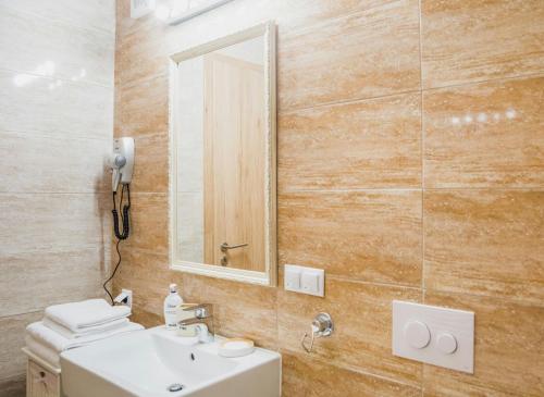 een badkamer met een wastafel en een spiegel bij Apartament 4Tourists in Braşov