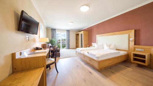 ein Hotelzimmer mit einem Bett und einem Schreibtisch in der Unterkunft Heuboden Hotel Landhaus Blum in Umkirch