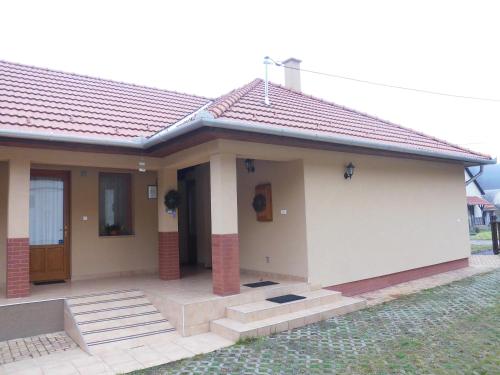 una pequeña casa con techo rojo en Dapsy Apartmanház, en Jósvafő