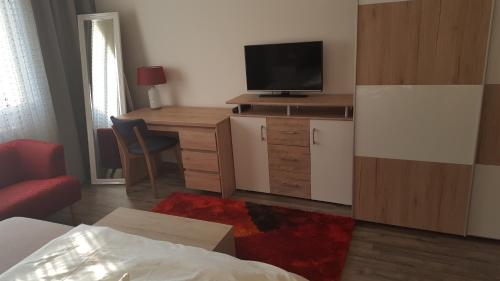 a living room with a tv and a desk with a tvictericterictericter at Ferienhaus Karall in Klingenbach