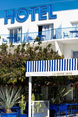 a hotel with a bench in front of a building at Hôtel La Reine Jane in Hyères