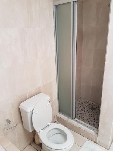 a bathroom with a toilet and a shower at 11 Villa Del Sol in Amanzimtoti