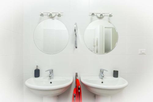a bathroom with two sinks and two mirrors at Leone X Genova Affittacamere in Genova