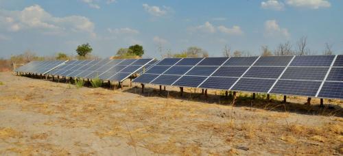 a row of solar panels in a field at Nogatsaa Pans Chobe Lodge in Kasane
