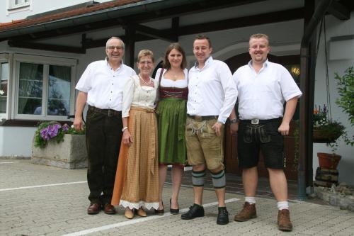 a group of people standing in front of a house at Hotel Neuwirt in Hallbergmoos