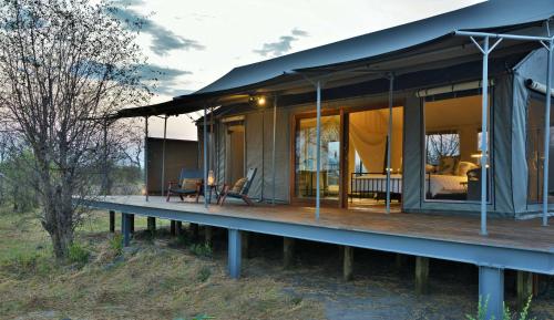 a house with a large deck with a bedroom at Nogatsaa Pans Chobe Lodge in Kasane