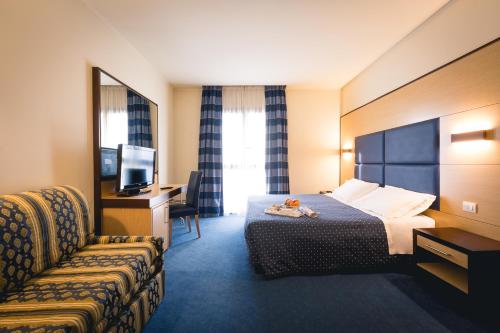 une chambre d'hôtel avec un lit et un canapé dans l'établissement Inn Hotel, à Barberino di Mugello