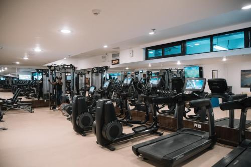 a gym with rows of treadmills and elliptical machines at Golden Tulip Addis Ababa in Addis Ababa