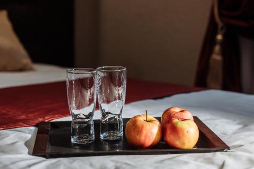 two glasses and apples on a tray on a table at Отель БЕССАРАБИЯ in Izmail