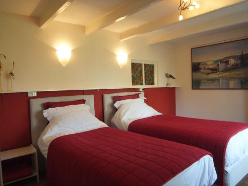 2 bedden in een hotelkamer met rode lakens bij Gastenverblijf 't Nagtegaeltje in Sint-Oedenrode