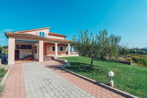 a house with a brick driveway in front of a yard at Villa Zen Imotski in Zmijavci