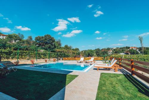 a backyard with a pool and chairs and a fence at Villa Zen Imotski in Zmijavci