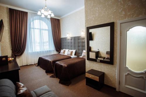 a hotel room with a bed and a mirror at Отель БЕССАРАБИЯ in Izmail