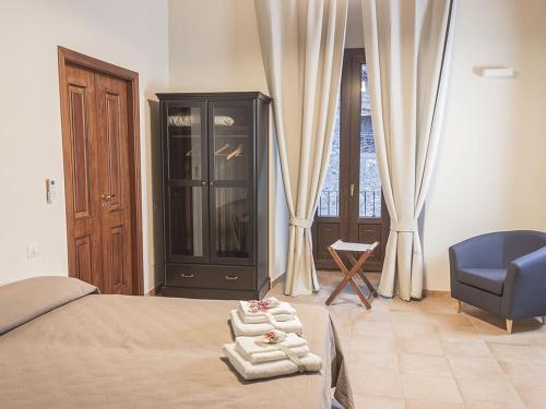una camera con un letto, una sedia blu e una finestra di B&B Domus Purpurea a Rossano