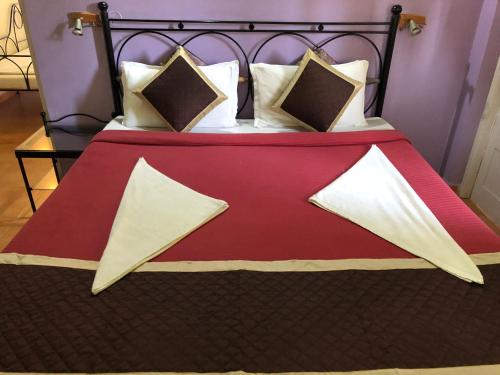 a bed with a red blanket and pillows on it at Libton Manor in Candolim