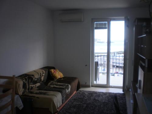 un soggiorno con divano e porta scorrevole in vetro di Apartman Ana a Omiš (Almissa)