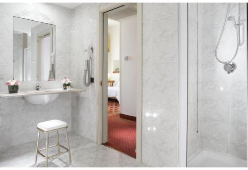 uma casa de banho com um chuveiro, um lavatório e um espelho. em Grande Albergo Internazionale em Brindisi
