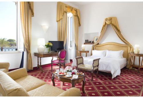 pokój hotelowy z łóżkiem i kanapą w obiekcie Grande Albergo Internazionale w mieście Brindisi