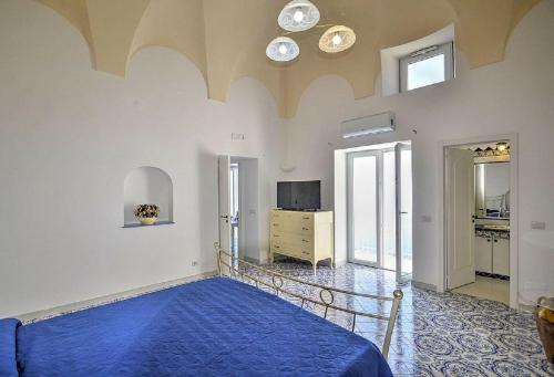 a bedroom with a blue bed and a television at Casa Rosetta in Praiano