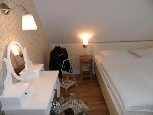 sypialnia z łóżkiem, umywalką i lustrem w obiekcie Ferienhaus im malerischen Ort Korswandt w mieście Korswandt