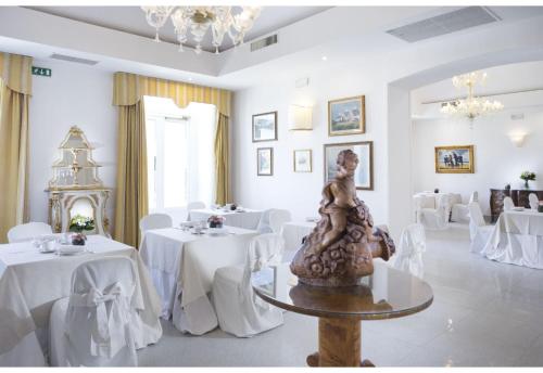 ブリンディジにあるGrande Albergo Internazionaleのダイニングルーム(白いテーブル、白い椅子付)