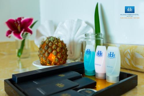 ハロンにあるHalong Harbour Hotelのパイナップルの横にコンピューターキーボードとミルク2本