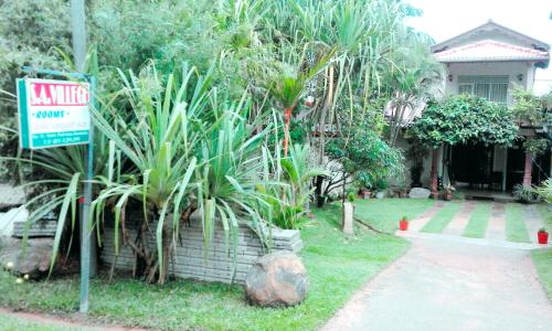 a sign in front of a house with plants at SA Village in Dambulla