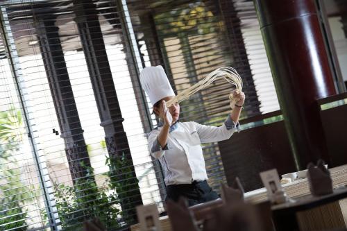 a person wearing a chefs hat holding a whisk at Hotel Santika Premiere Semarang in Semarang