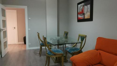 ein Esszimmer mit einem Glastisch und Stühlen in der Unterkunft San Anton Centro Apartment in Logroño